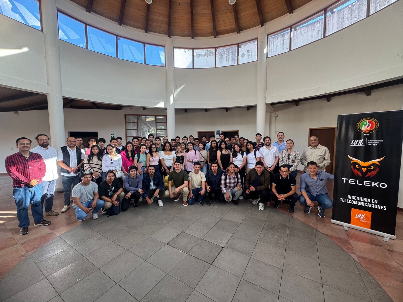 Grupo grande de jóvenes reunidos en un espacio universitario, conversando tras una jornada de gobernanza digital